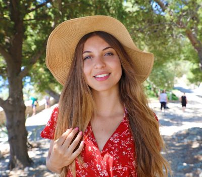Beautiful Smiling Girl Wearing Red Dress And Hat Looking At Came